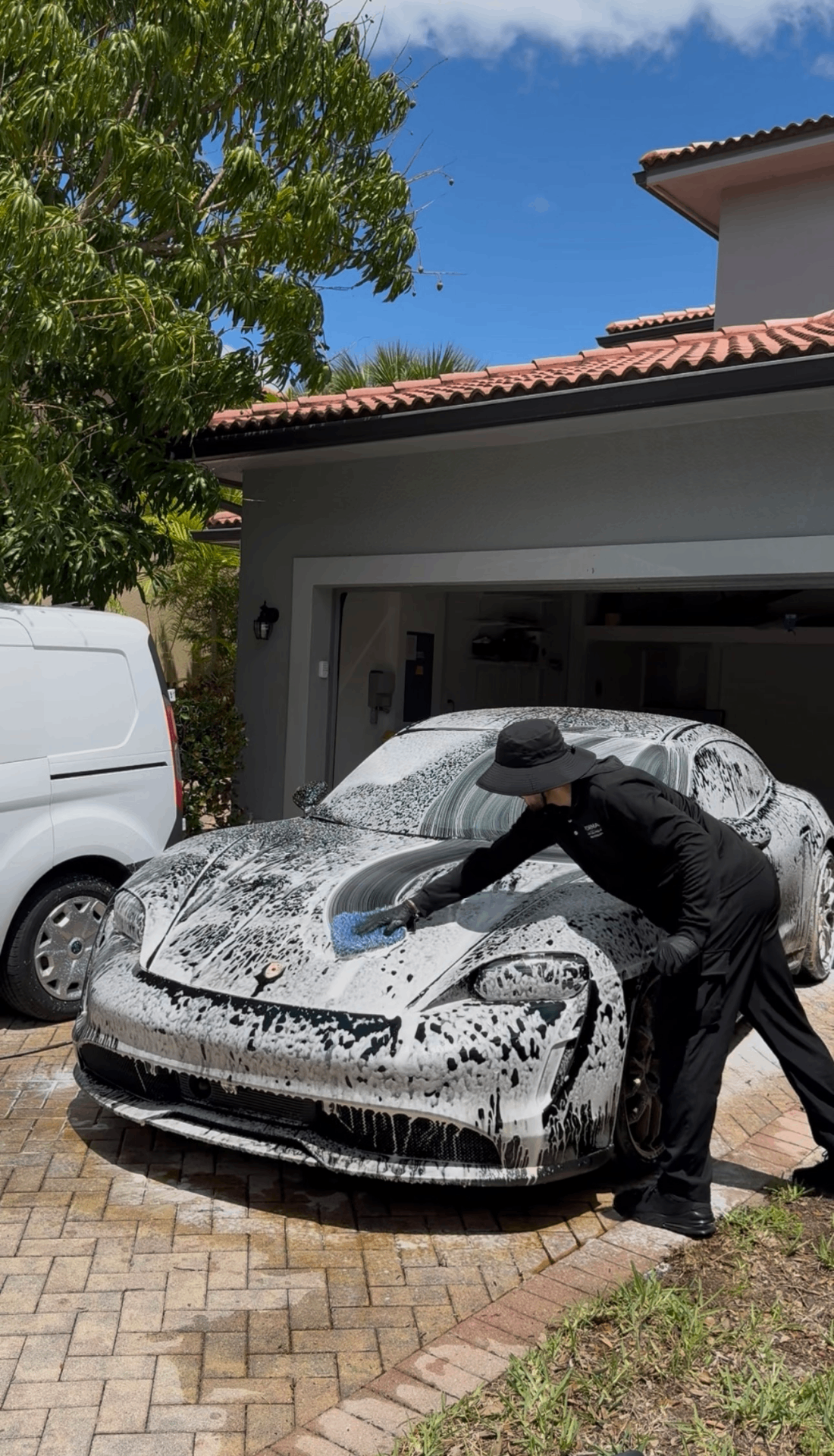 FORMA Detailing technician performing a foam wash on a sports car in a Naples driveway
